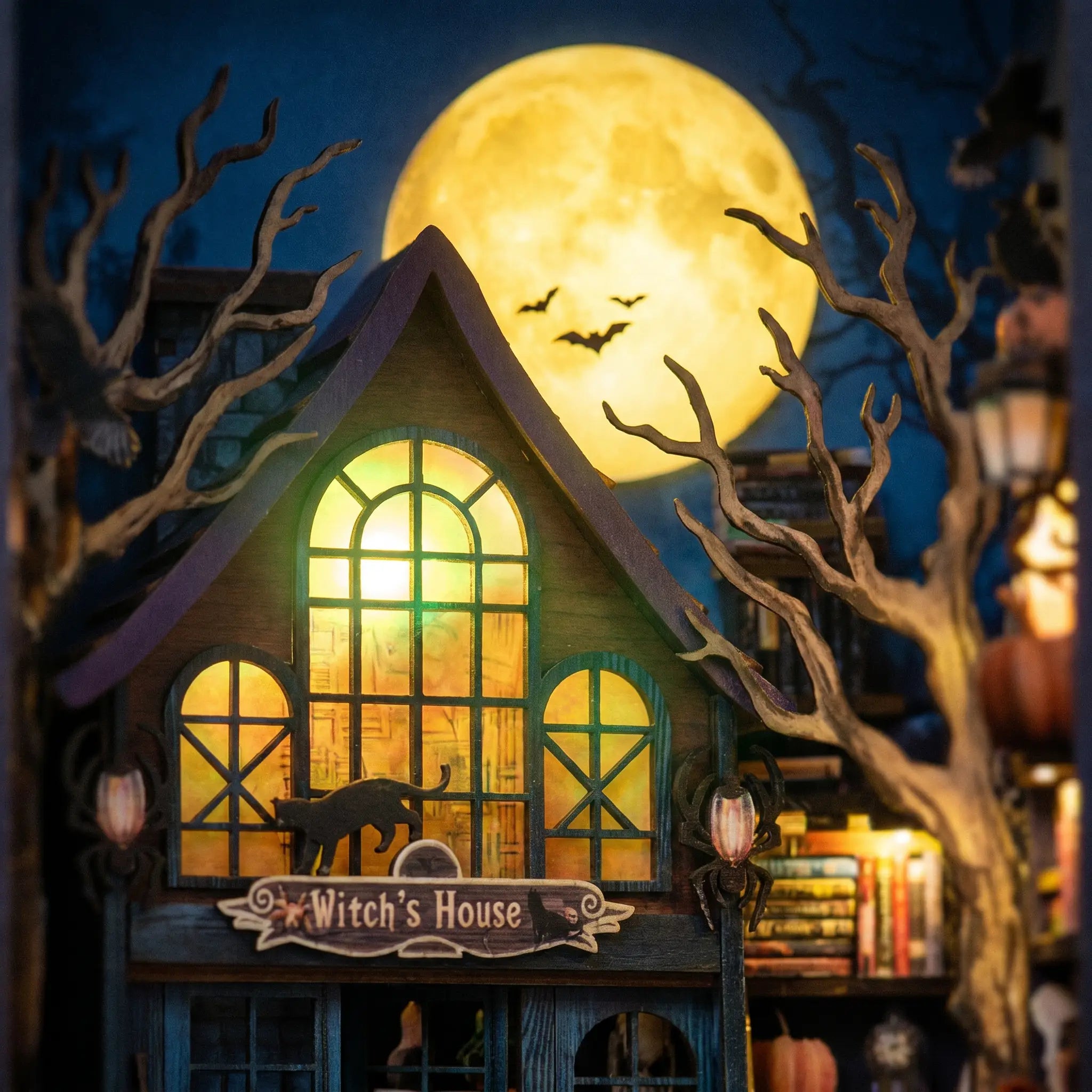 Close-up of the full moon and bats above The Haunted Manor book nook