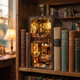 The Detective's Study book nook slotted on a bookshelf between books at dusk