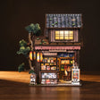The Corner Store miniature on a dark walnut backdrop with glowing storefront