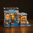 The Santorini Café miniature coffee shop roombox, front three-quarter view on a dark backdrop with warm LED lighting