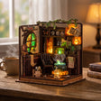 The Potion Workshop on a wood desk with a mug and books at dusk