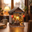 The Izakaya miniature pub on a wood desk with a mug and books at dusk