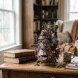 The Moving Castle sculpture displayed on a cozy wooden study desk
