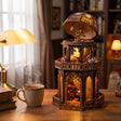 The Observatory tower on a wood desk with a mug and books, lights glowing