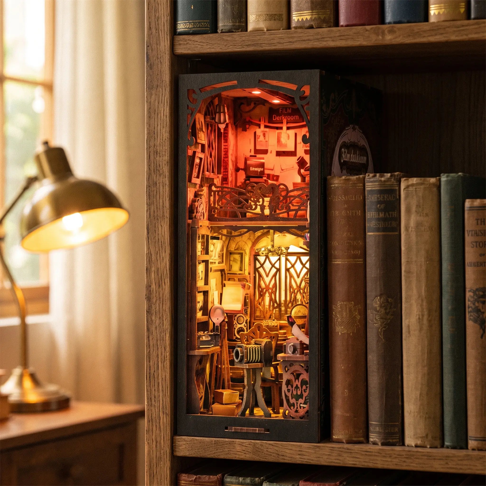 The Darkroom book nook slotted on a bookshelf between books at dusk