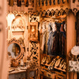 Close-up of the lit dressing room interior, gowns and vanity