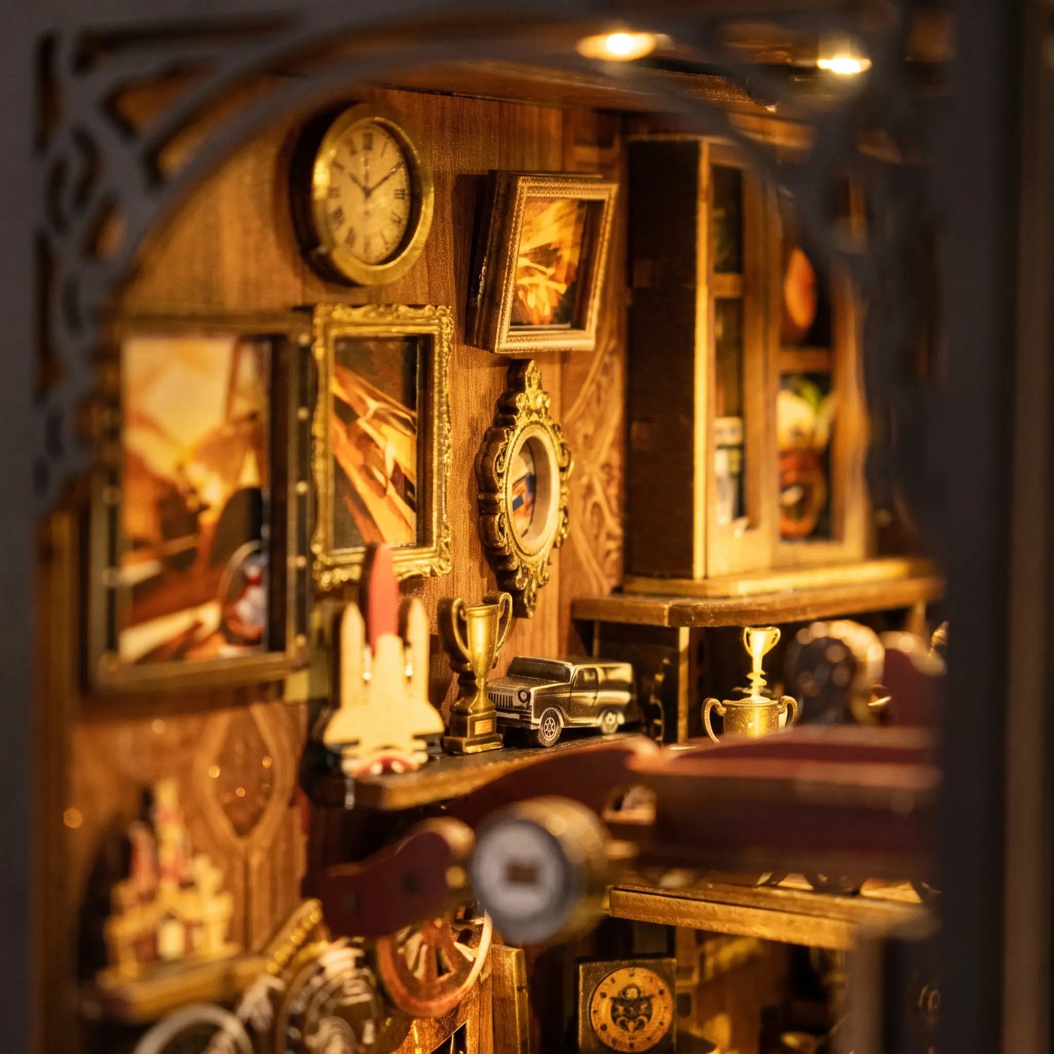 Close-up of the framed poster wall and brass clock in The Classic Garage