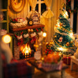 Close-up of the glowing fireplace and lit Christmas tree inside The Christmas Parlour