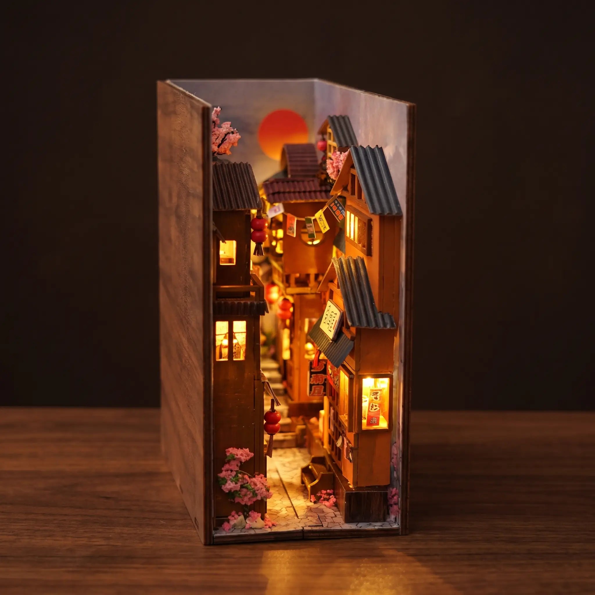 The Lantern Alley book nook on a dark walnut backdrop with warm amber lantern glow