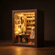 The Dressmaker's Shop book nook on a dark walnut backdrop, warm interior glow