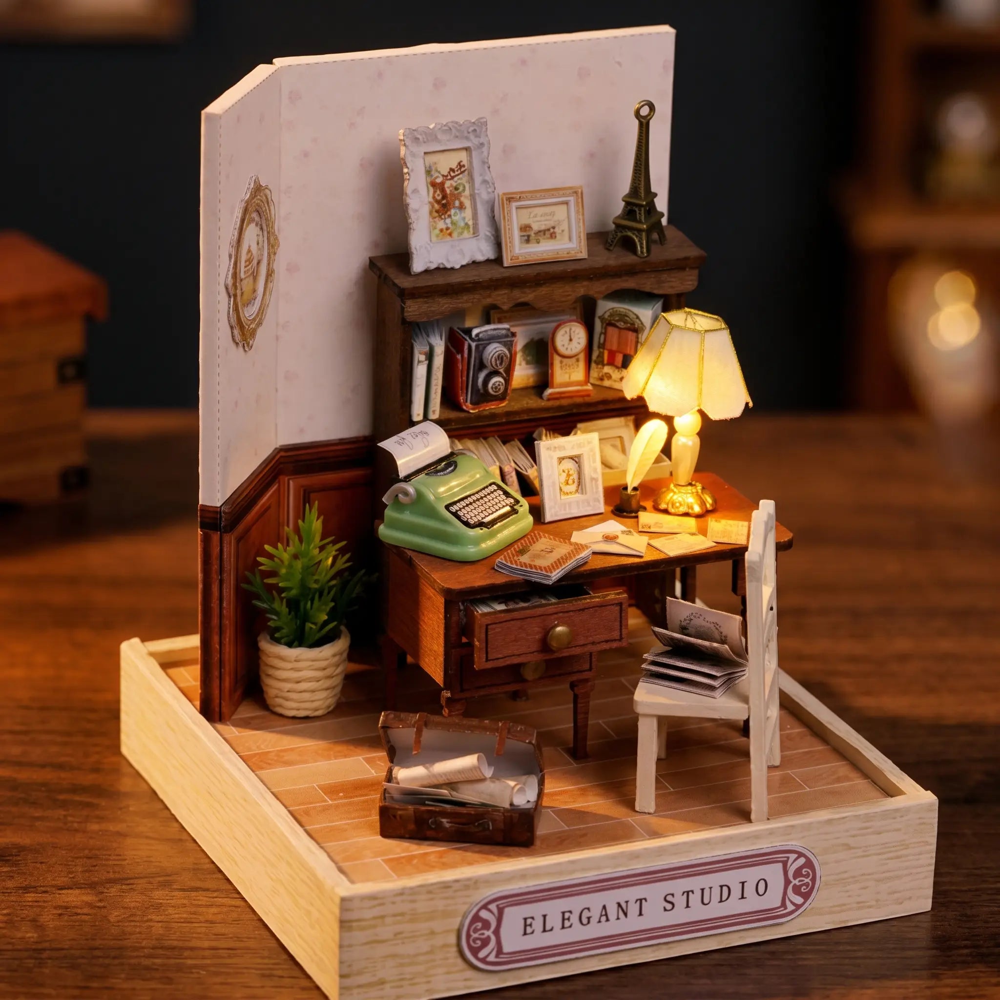 The Writer's Room miniature on a dark walnut backdrop, desk lamp glowing