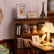 Detail of the bookshelf with books and a tiny Eiffel Tower figurine