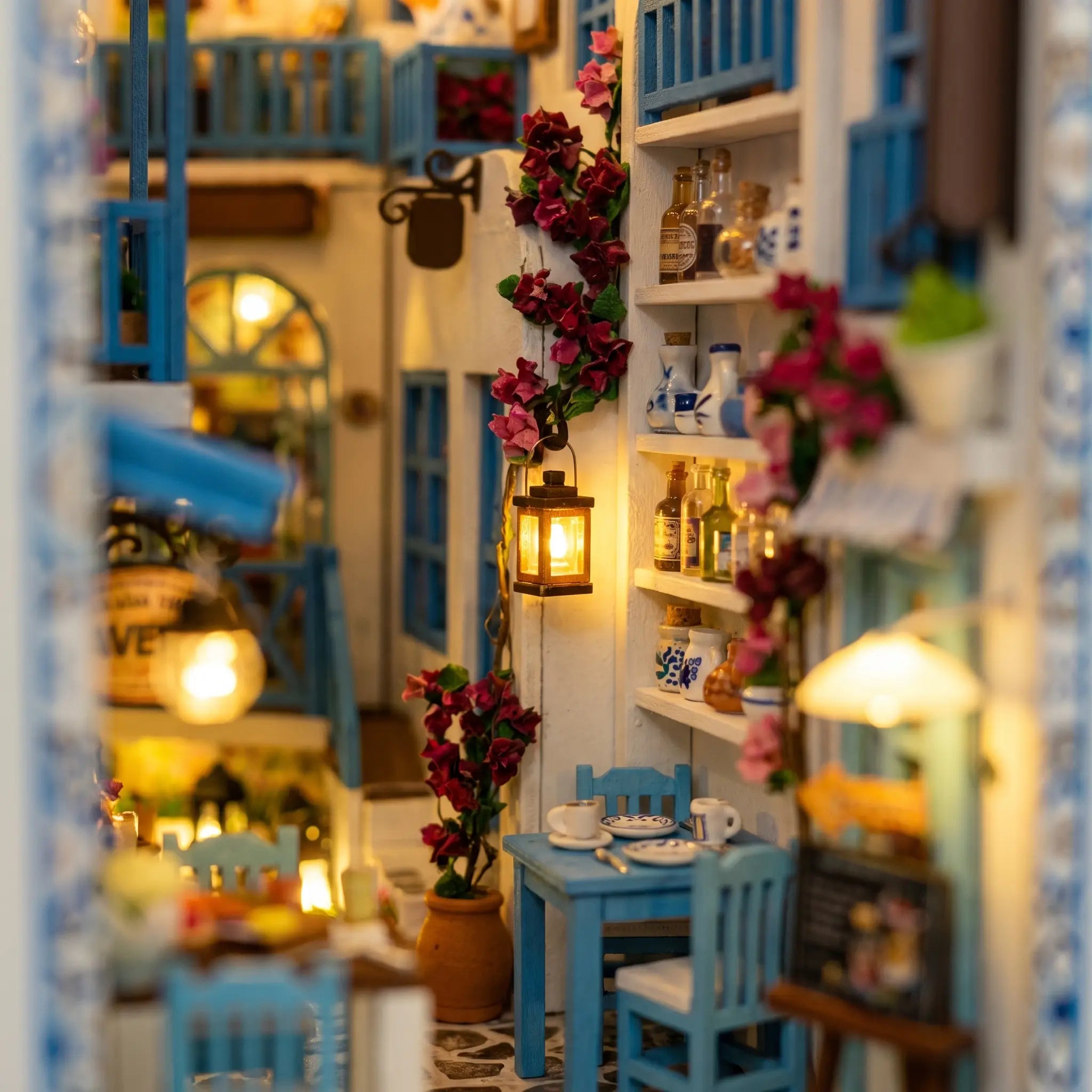 Close-up of the lit taverna inside The Aegean Alley miniature book nook