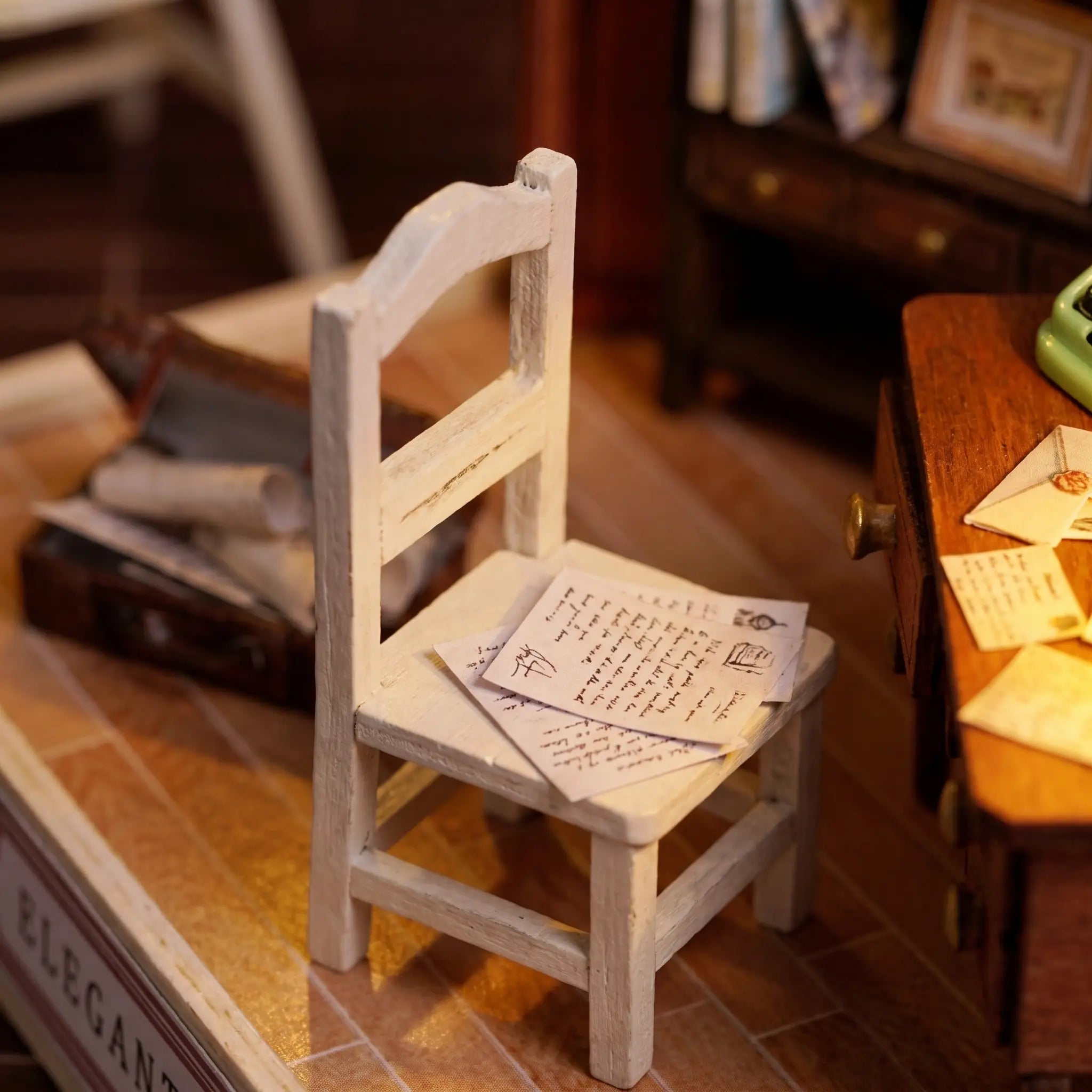 Detail of the wooden armchair and open suitcase beside the desk