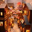 Close-up of a pink cherry-blossom branch glowing in The Lantern Alley book nook