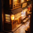 Close-up of a glowing tiled wooden shopfront in The Lantern Alley book nook