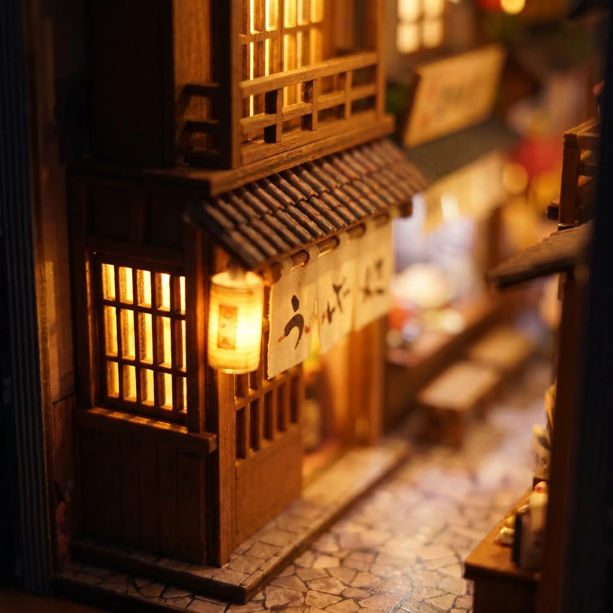 Close-up of a glowing tiled wooden shopfront in The Lantern Alley book nook