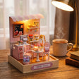 The Cake Shop on a warm wood desk with a mug and books