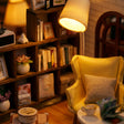 Close-up of the glowing lamp and mustard armchair inside The Quiet Corner