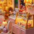 Close-up of the lit cake display counter inside The Cake Shop