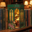 The Owl Bookshop slotted on a bookshelf between books, glowing warmly at dusk