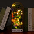 The Firefly Forest DIY book nook lit on dark walnut