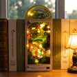 The Firefly Forest book nook slotted on a shelf between books
