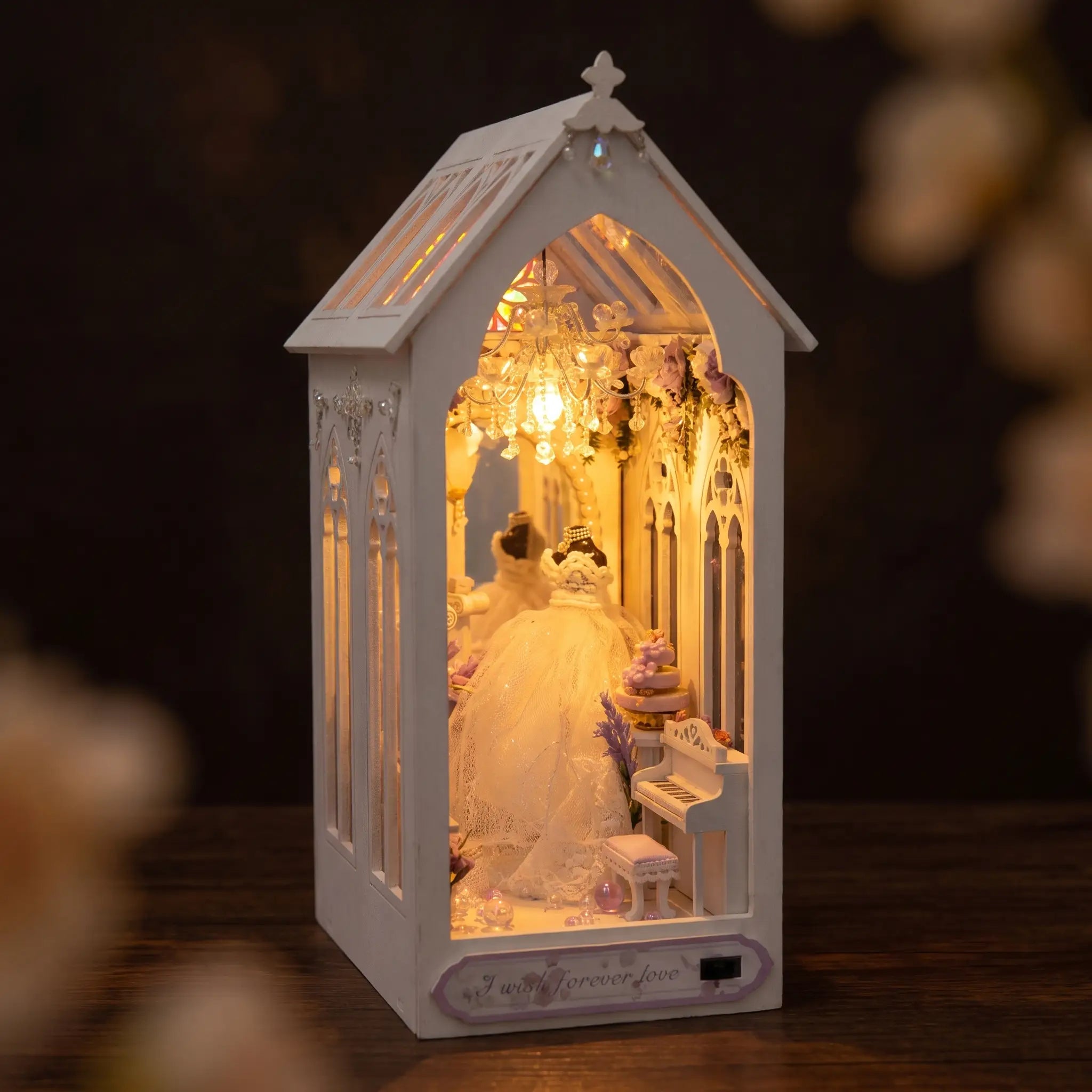 The Wedding Chapel book nook on dark walnut, white gothic chapel glowing with rose window and chandelier
