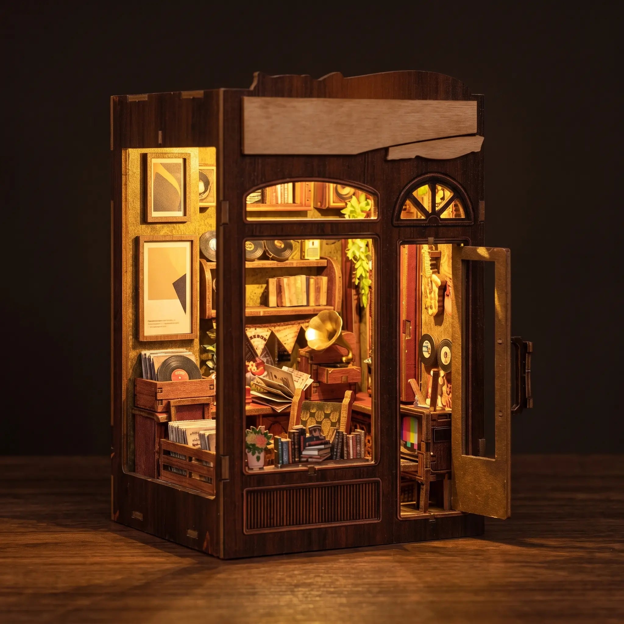The Record Shop book nook on a dark walnut backdrop with warm interior lights glowing