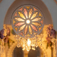 Close-up of the stained-glass rose window glowing in the wedding chapel