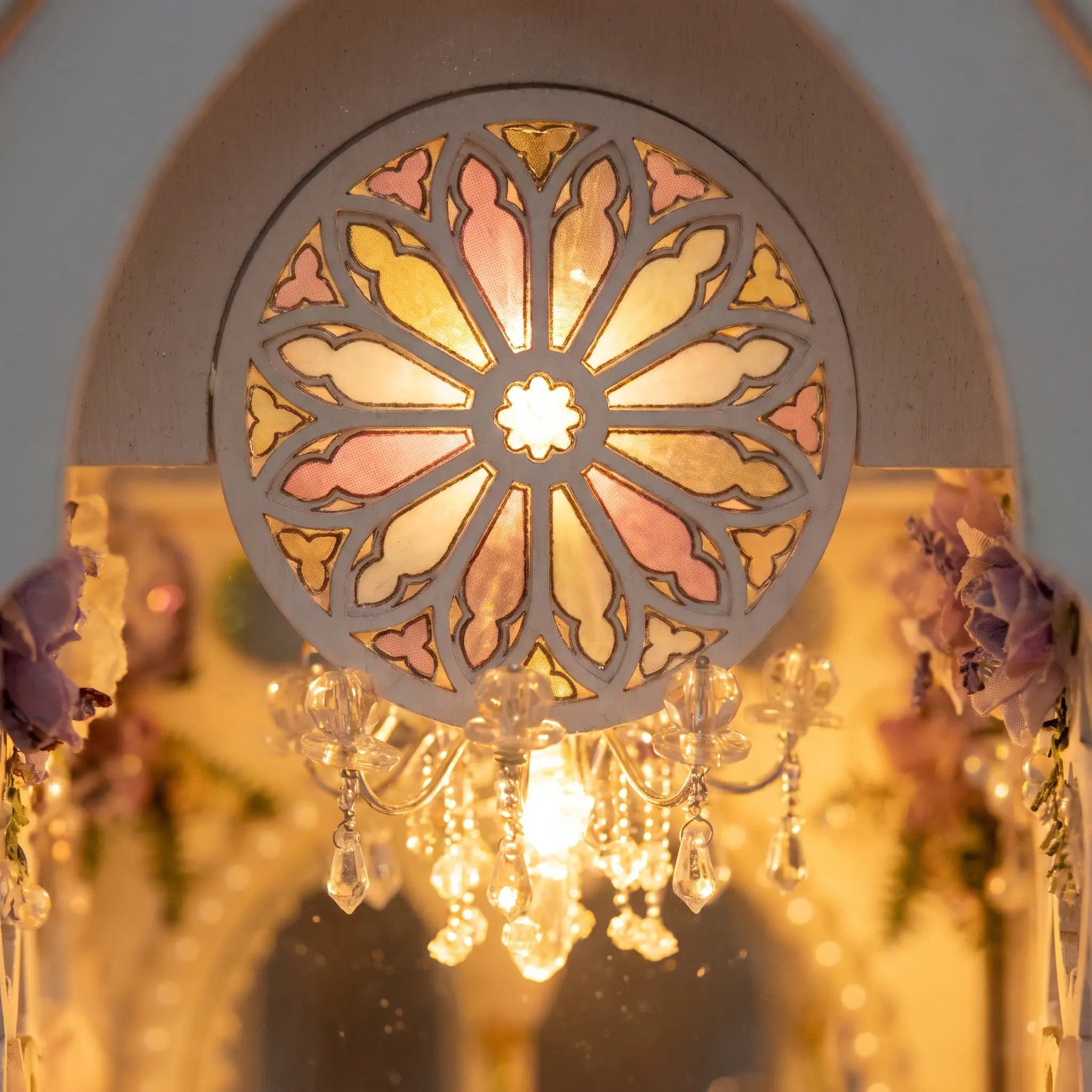 Close-up of the stained-glass rose window glowing in the wedding chapel