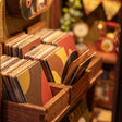 Detail of wooden crates packed with tiny vinyl records in The Record Shop book nook