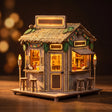 The Tiki Bar miniature on a dark walnut backdrop with glowing neon and warm interior