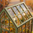 Close-up of the peaked glass conservatory roof with sage-green glazing bars and daylight
