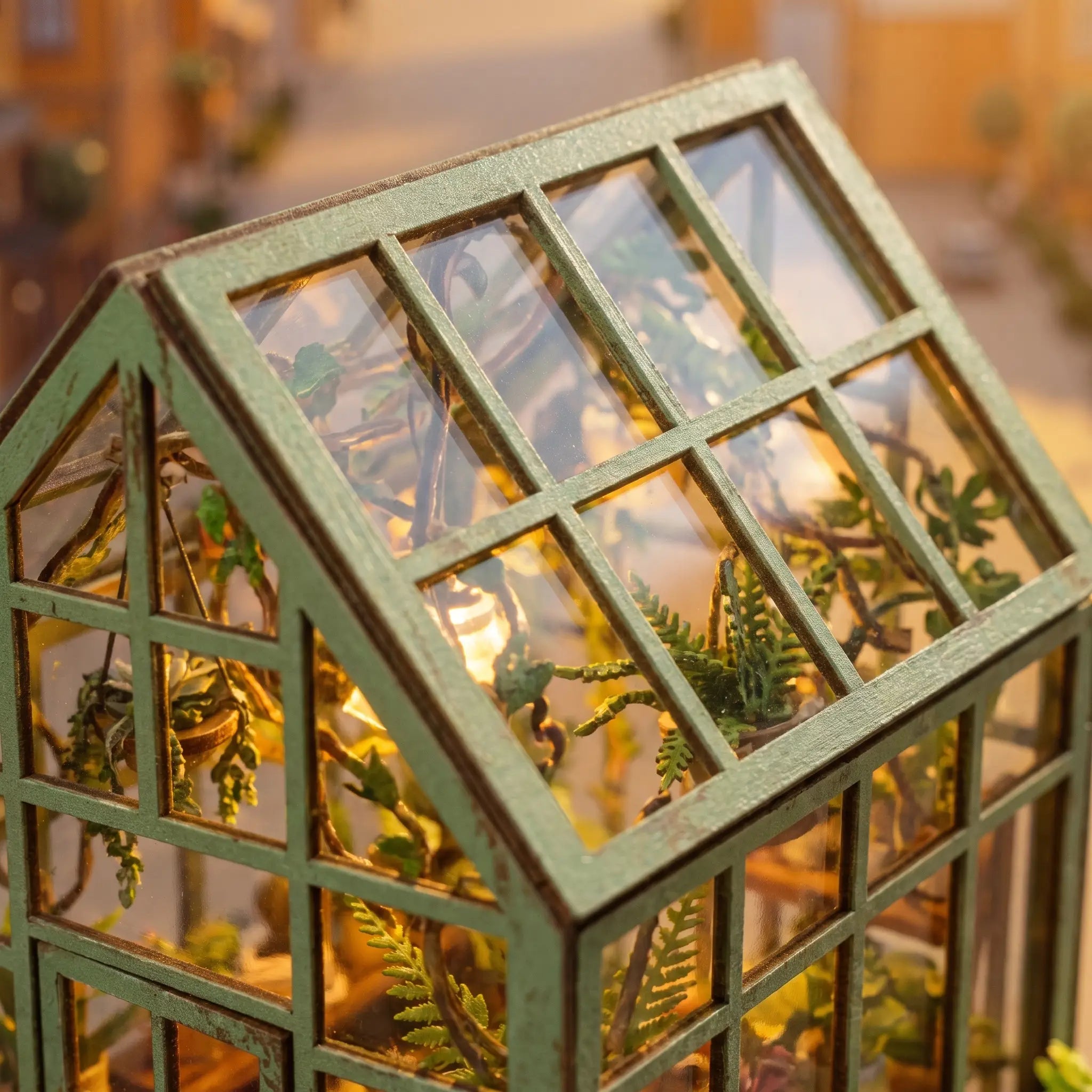 Close-up of the peaked glass conservatory roof with sage-green glazing bars and daylight