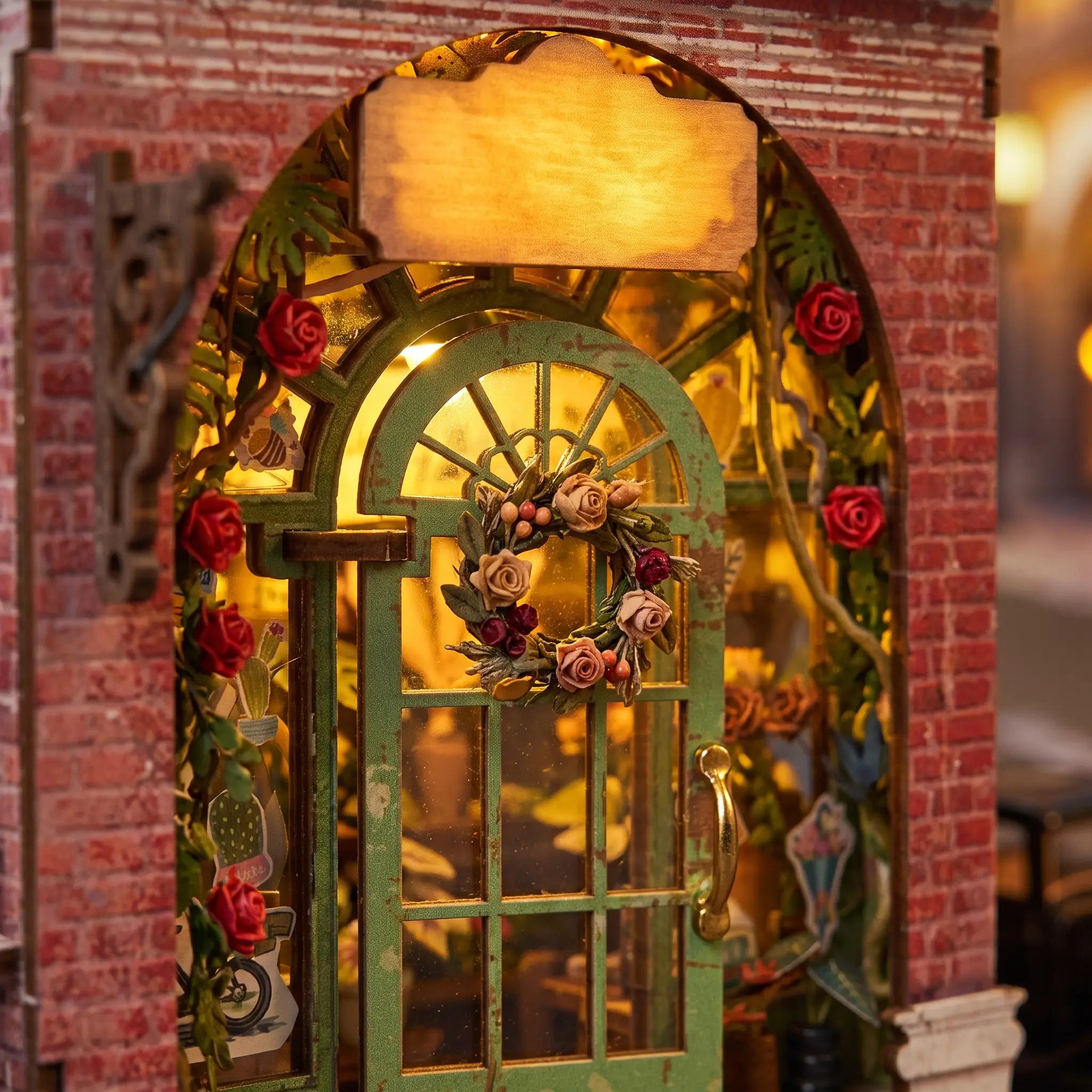 The Blossom House detail, the arched green glass-paned door glowing warm