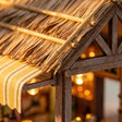 Macro detail of the thatched bamboo roof catching warm sunset light