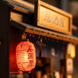 Close-up of the glowing red izakaya lantern and sign board