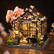 The Sakura Teahouse lit interior on a dark walnut backdrop