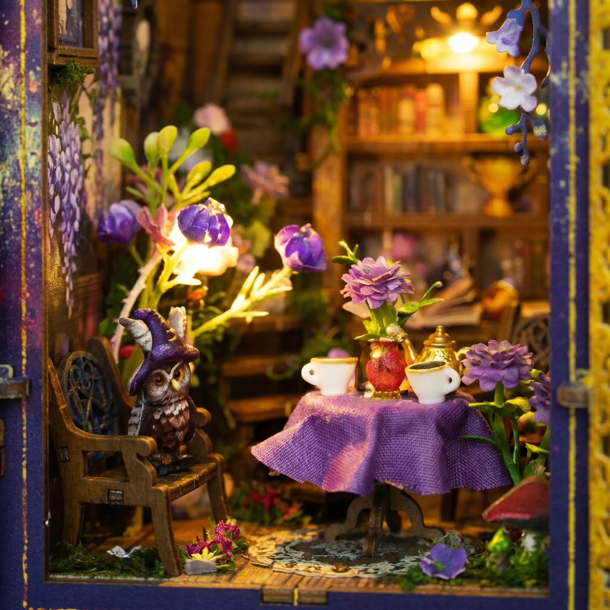 The Midnight Garden tea table close-up with purple tablecloth, gold teapot and the owl in a wizard hat