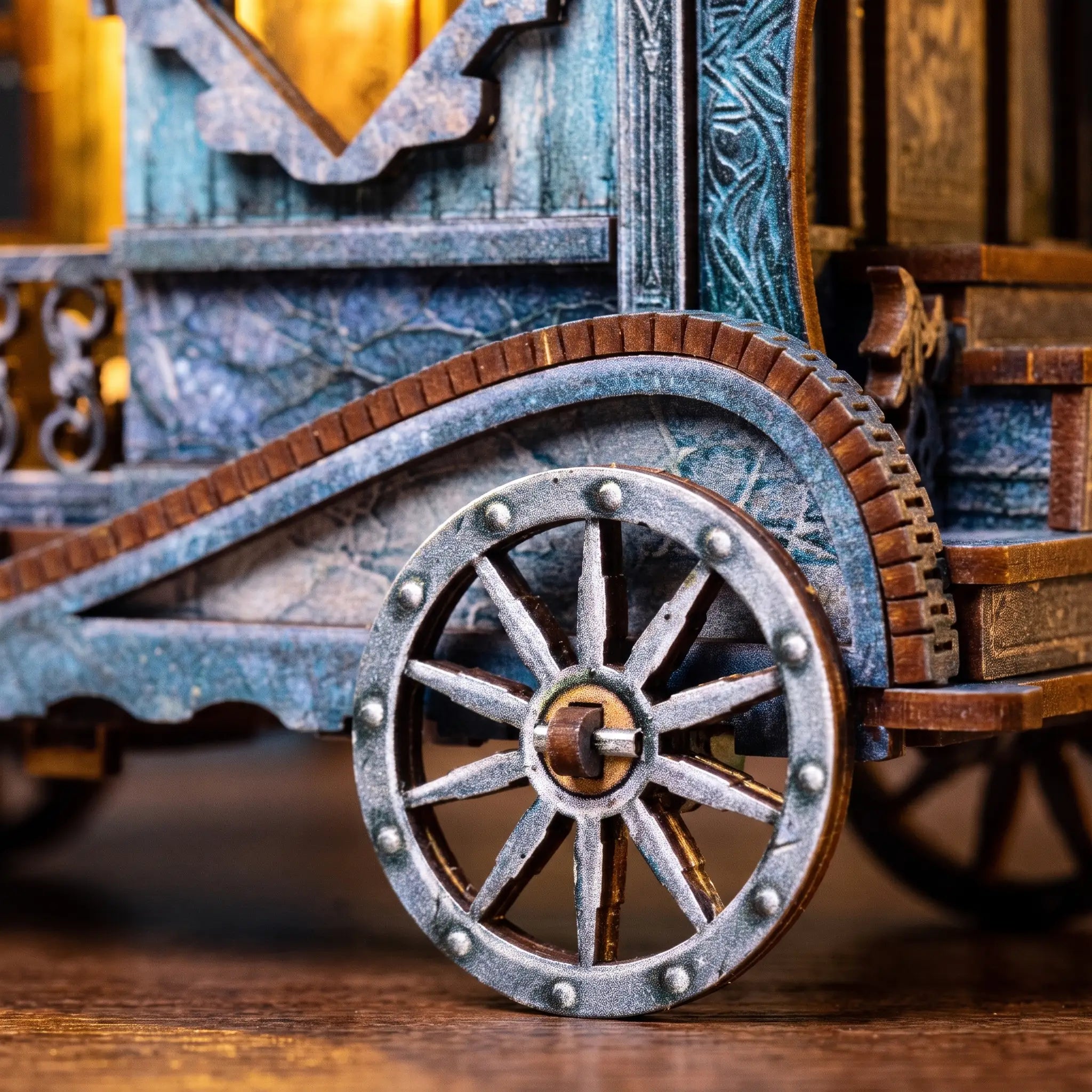 Close up of the iron spoked wheel and carved blue panels