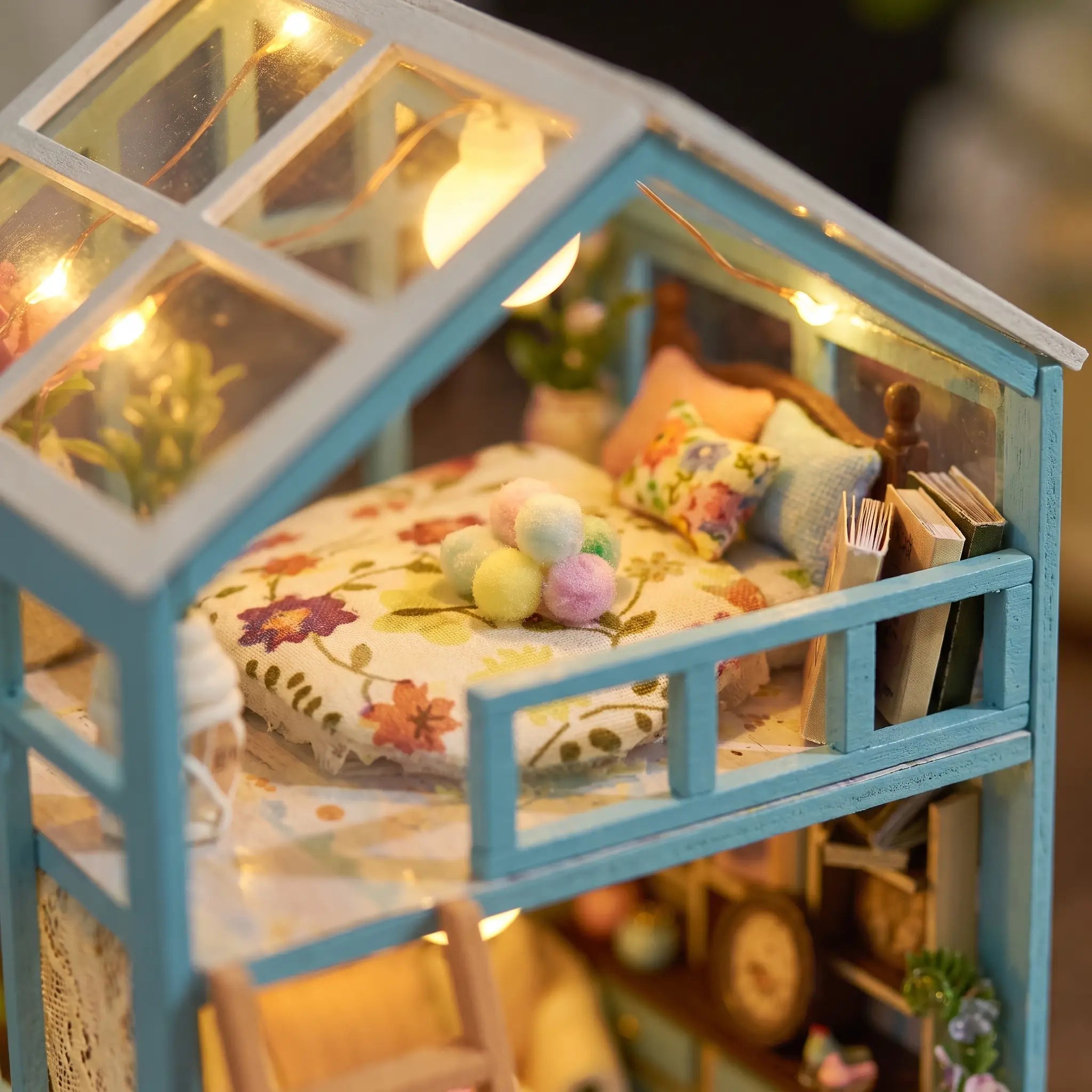 Close up of the loft bed with floral quilt under the glass roof