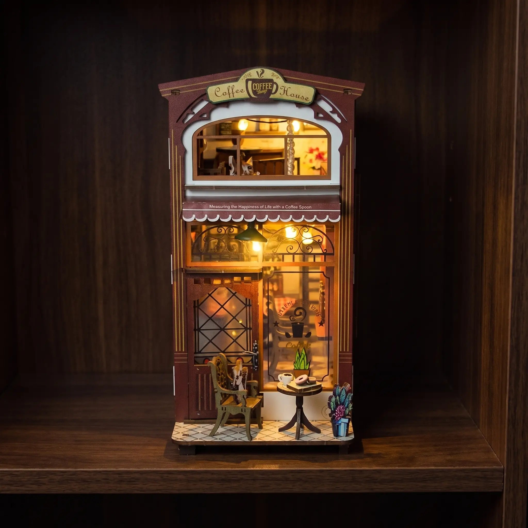 The Coffee House book nook glowing on a dark walnut shelf at night
