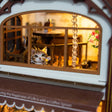 Lit mezzanine window detail of The Coffee House with peeking cat