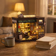 The Witching Hour on a wooden desk at dusk beside a mug of tea