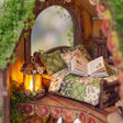 Close up of the loft bed with quilted pillows, storybook and flower lantern inside The Mossy Hollow