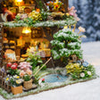 Close up of the snowy garden with white rabbit, fishing rod and frozen pond