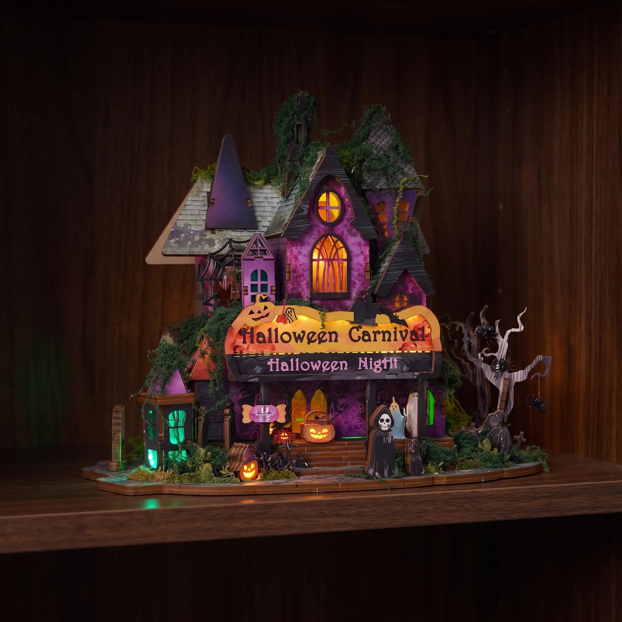The Halloween Carnival glowing on a dark walnut shelf at night