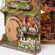 Close up of the red squirrel window, watering can and daisy picket fence on The Mossy Hollow