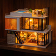 The Glass Villa miniature kit glowing on a dark walnut shelf at night